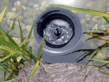 Skimmer sbírající nečistoty z hladiny koupacího jezírka