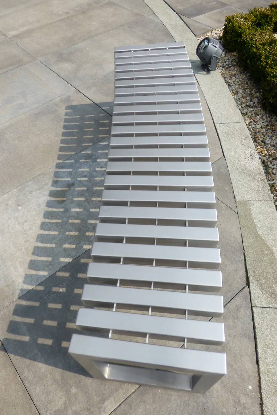 Detail obloukového tvaru nerezové lavičky s paprskovitou konstrukcí