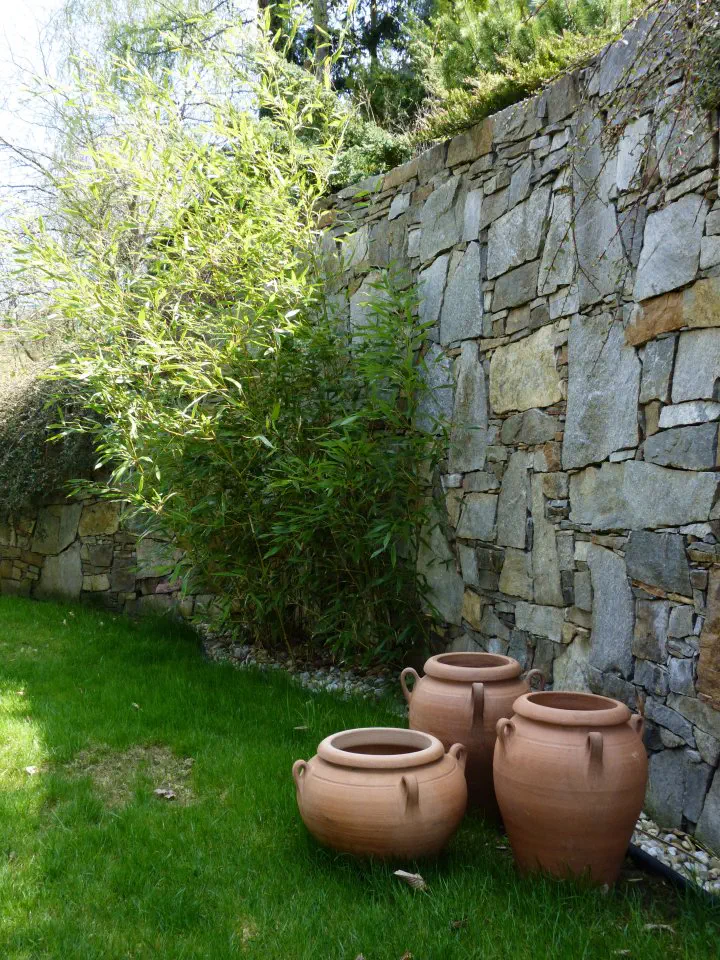 Opěrná zeď je zpestřena bambusem a dekorována keramikou